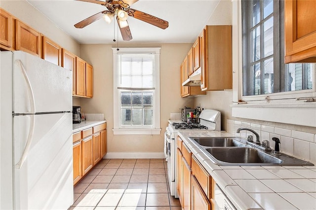 kitchen with sink, white appliances, ceiling fan, light tile patterned flooring, and decorative backsplash