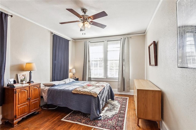 bedroom with ornamental molding, dark hardwood / wood-style floors, and ceiling fan