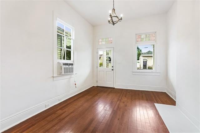 entrance foyer featuring cooling unit, dark hardwood / wood-style floors, and an inviting chandelier