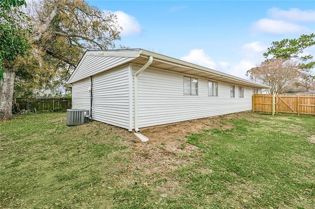 view of property exterior with central AC unit and a yard