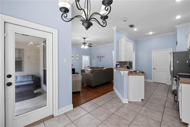 kitchen featuring light tile patterned flooring, white cabinets, crown molding, and kitchen peninsula