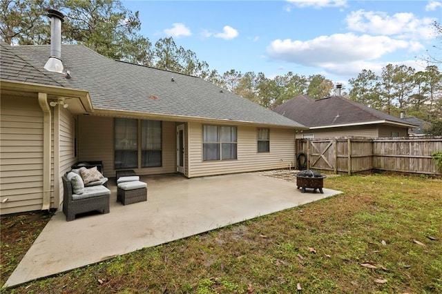 rear view of property with a lawn, a patio area, and an outdoor fire pit