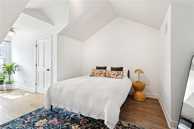 bedroom featuring lofted ceiling and hardwood / wood-style floors