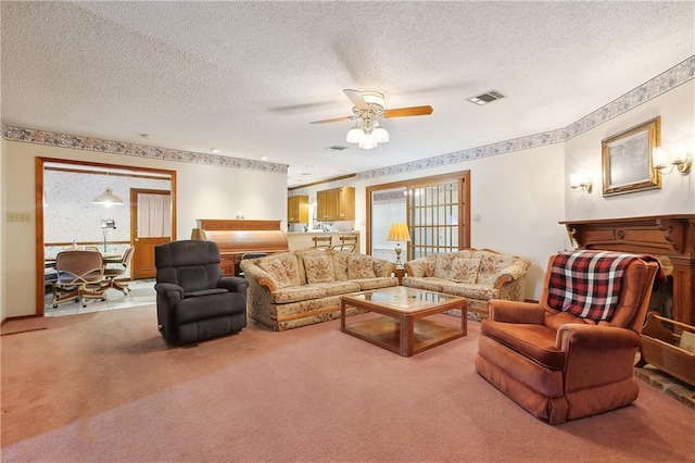 carpeted living area with a textured ceiling, ceiling fan, visible vents, and plenty of natural light
