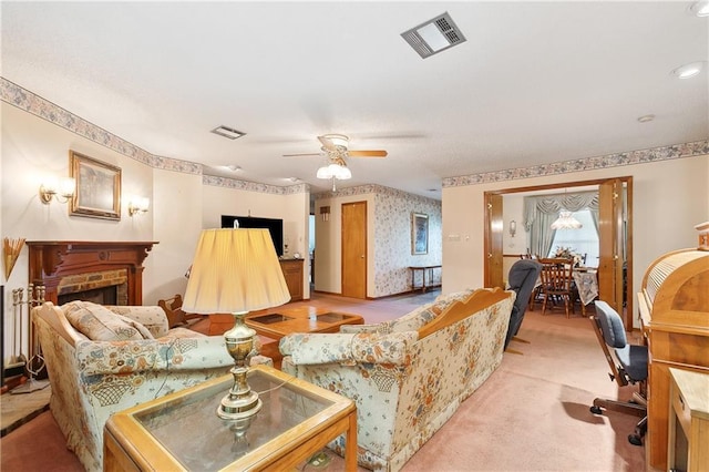 living area featuring visible vents, a ceiling fan, light colored carpet, and wallpapered walls