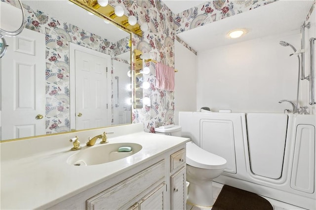 bathroom with walk in shower, vanity, wallpapered walls, and toilet