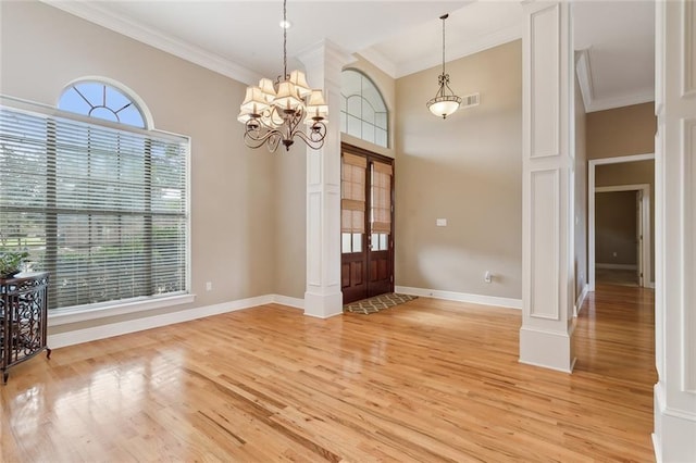 entryway with hardwood / wood-style flooring, ornamental molding, and a healthy amount of sunlight