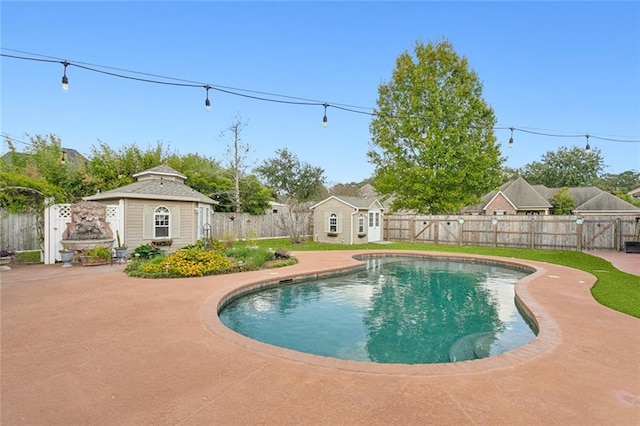 view of pool featuring a fenced backyard, an outbuilding, a gate, and an exterior structure