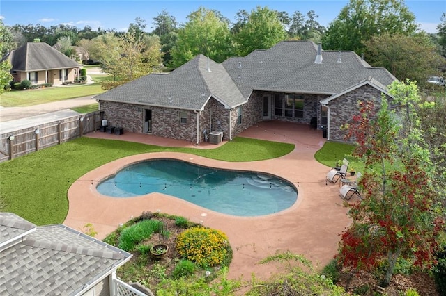 view of swimming pool with a yard, a patio area, and central air condition unit