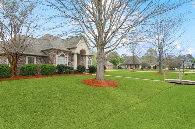 view of front of property featuring brick siding and a front yard