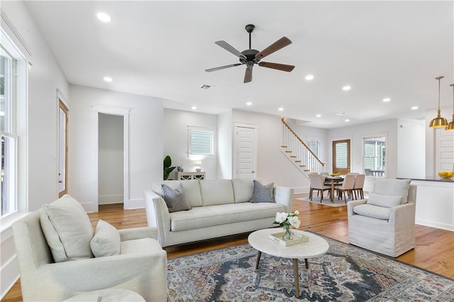 living room featuring ceiling fan and light hardwood / wood-style floors