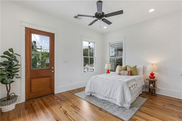 bedroom with multiple windows, light hardwood / wood-style flooring, and ceiling fan