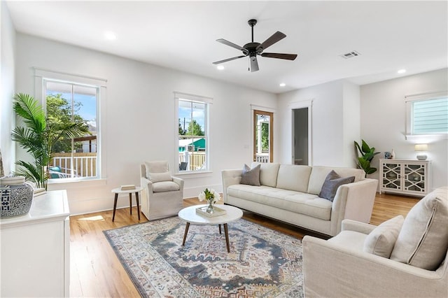 living room with ceiling fan and light hardwood / wood-style flooring