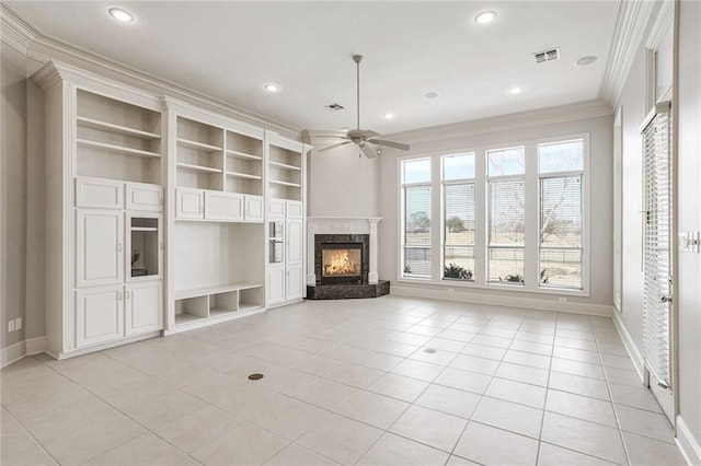 unfurnished living room featuring light tile patterned flooring, a fireplace, ceiling fan, crown molding, and built in shelves