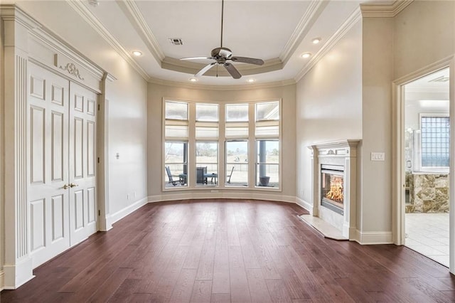 interior space with a tray ceiling, dark hardwood / wood-style flooring, and a wealth of natural light