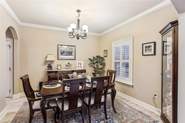 dining room with ornamental molding, a chandelier, and light wood-type flooring