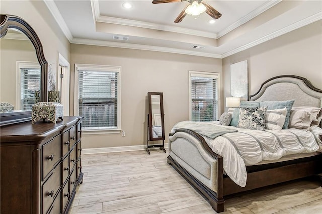 bedroom with ceiling fan, ornamental molding, a raised ceiling, and light hardwood / wood-style flooring