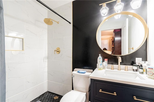 bathroom featuring vanity, tiled shower, and toilet