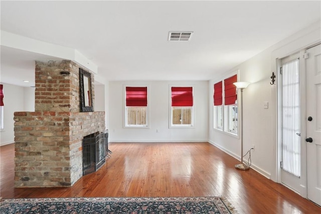 unfurnished living room featuring hardwood / wood-style floors and a fireplace