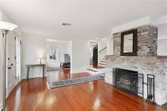 5817 Magnolia St, New Orleans, LA 70115 - living room featuring hardwood / wood-style floors, stairway, baseboards, and a brick fireplace