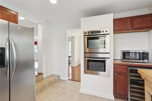 kitchen featuring appliances with stainless steel finishes, beverage cooler, and light tile patterned floors