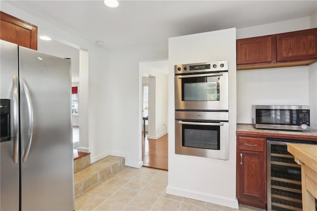 5817 Magnolia St, New Orleans, LA 70115 - kitchen featuring appliances with stainless steel finishes, wine cooler, light countertops, light tile patterned floors, and baseboards