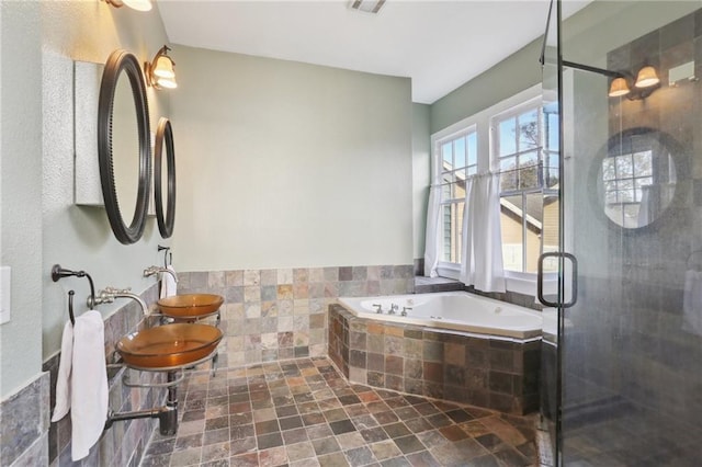 bathroom featuring plus walk in shower and dual sinks