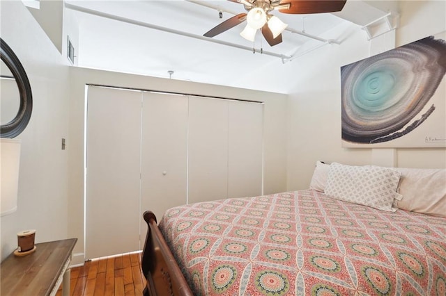 bedroom featuring ceiling fan, hardwood / wood-style floors, and a closet