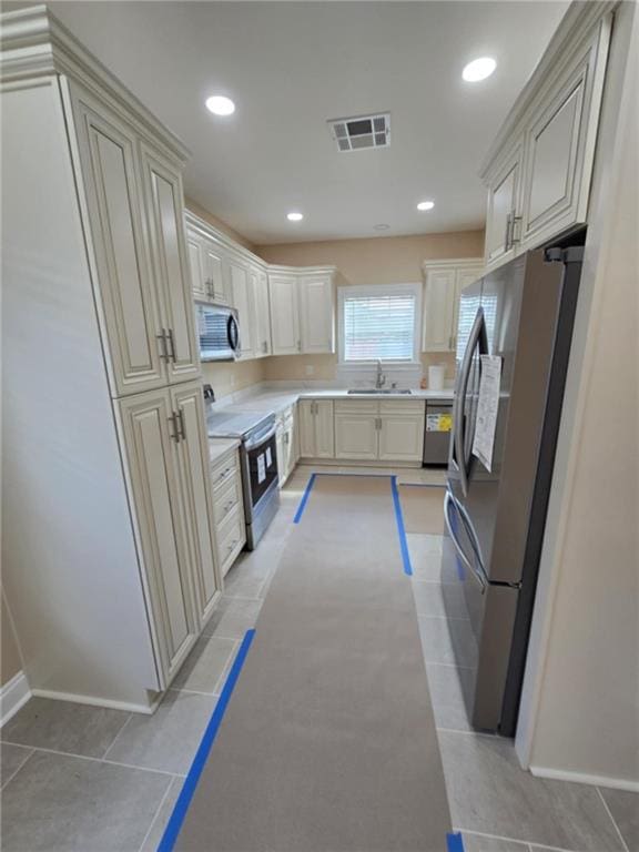 kitchen with light tile patterned flooring, appliances with stainless steel finishes, and sink