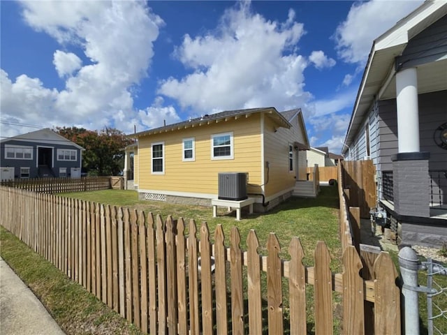 view of property exterior with cooling unit and a lawn