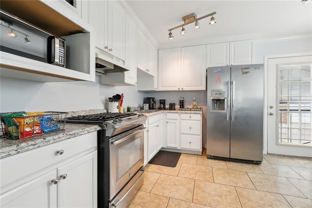 kitchen with rail lighting, appliances with stainless steel finishes, light stone counters, white cabinets, and light tile patterned flooring