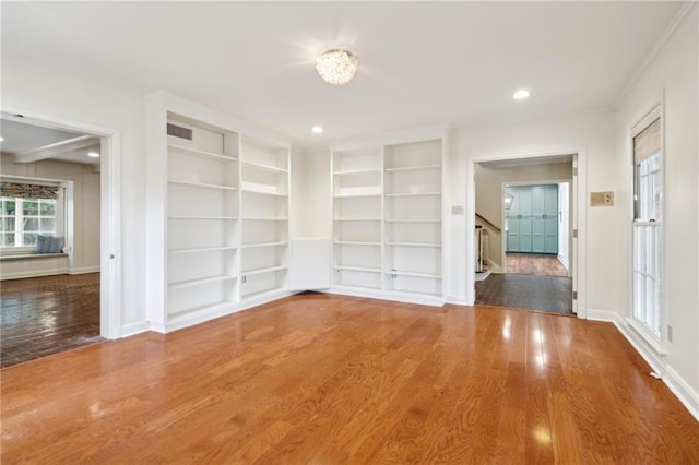 spare room with hardwood / wood-style flooring and built in shelves