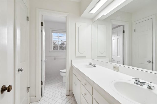 bathroom featuring vanity, tile patterned flooring, and toilet