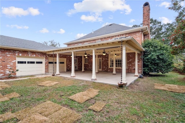 exterior space with ceiling fan, a garage, a patio area, and a lawn