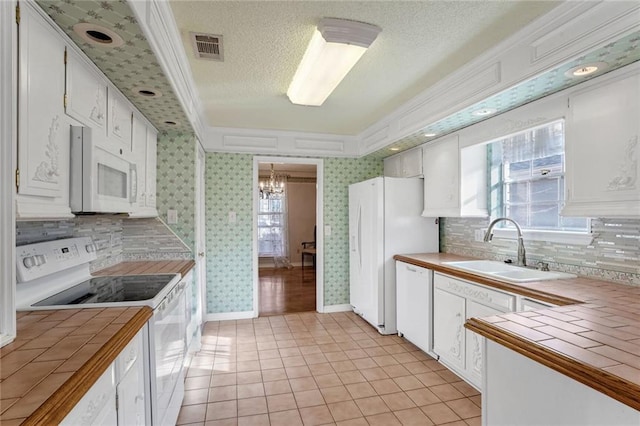 kitchen featuring white cabinetry, white appliances, and tile countertops