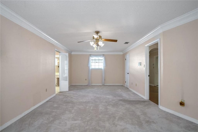 spare room featuring light carpet, ceiling fan, crown molding, and a textured ceiling