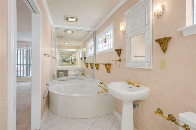 bathroom featuring a washtub, plenty of natural light, tile patterned floors, and toilet