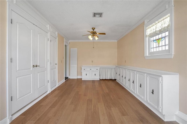 washroom with crown molding, ceiling fan, a textured ceiling, and light hardwood / wood-style flooring