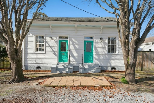 shotgun-style home featuring fence and entry steps
