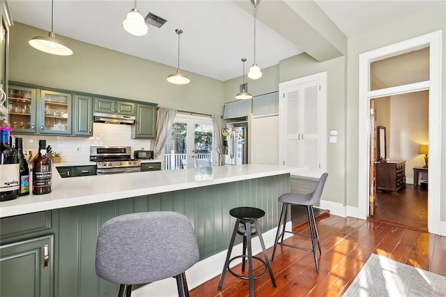 kitchen featuring appliances with stainless steel finishes, kitchen peninsula, hanging light fixtures, and a breakfast bar area