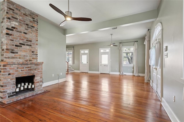 unfurnished living room featuring ceiling fan, baseboards, and hardwood / wood-style floors