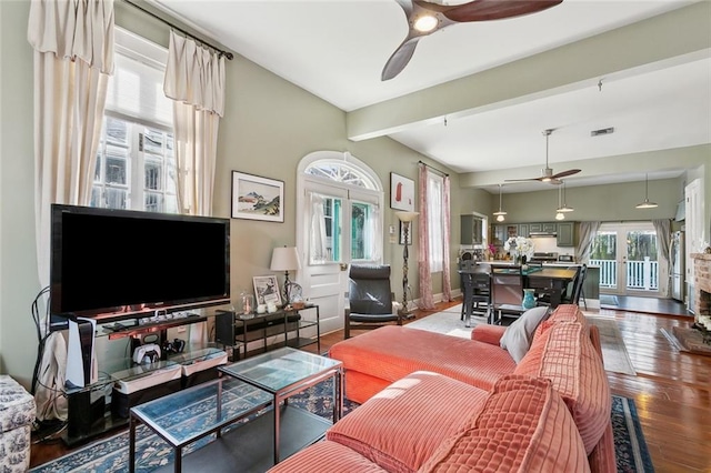 living room featuring hardwood / wood-style flooring, beamed ceiling, french doors, and ceiling fan