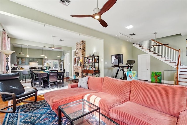 living room with hardwood / wood-style flooring, track lighting, and ceiling fan