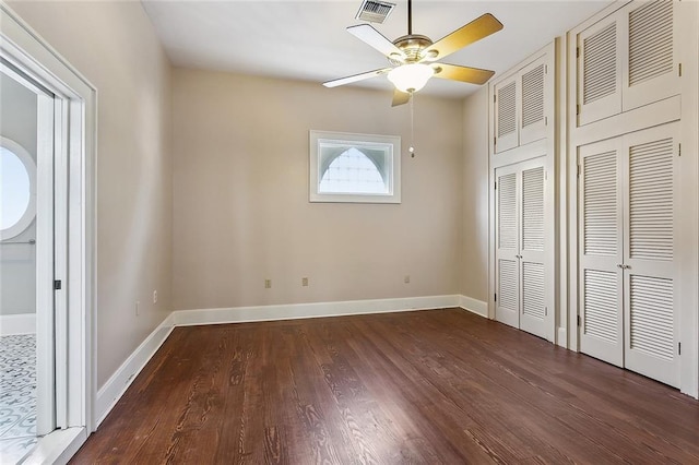 unfurnished bedroom with a ceiling fan, baseboards, visible vents, and wood finished floors