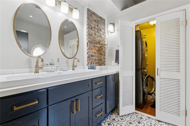 bathroom featuring vanity, stacked washer / drying machine, tile patterned floors, and crown molding