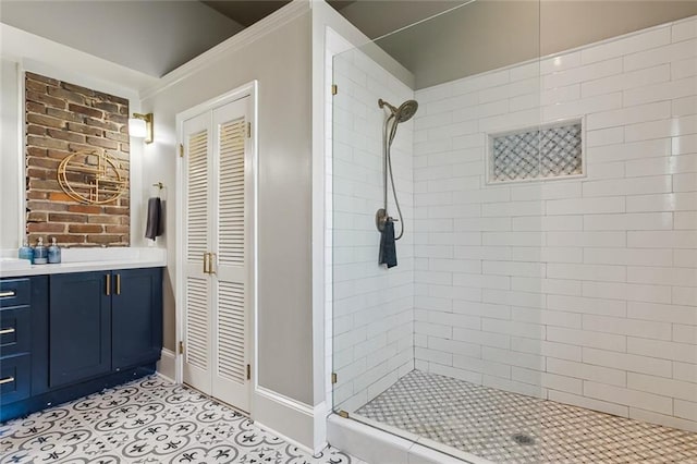 bathroom featuring a tile shower, vanity, and tile patterned flooring