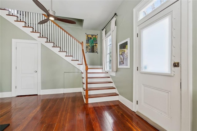 foyer entrance featuring baseboards, ceiling fan, hardwood / wood-style flooring, and stairway