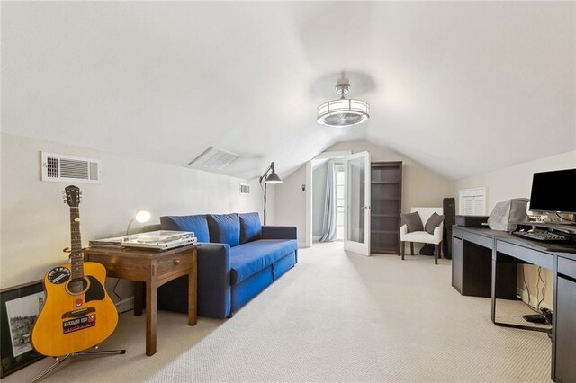 interior space featuring vaulted ceiling, light colored carpet, and visible vents
