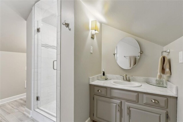 bathroom featuring vanity, baseboards, and a stall shower