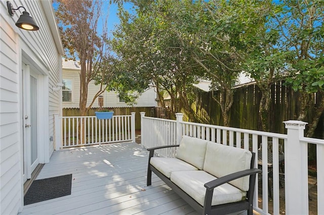 wooden terrace featuring an outdoor hangout area and a fenced backyard